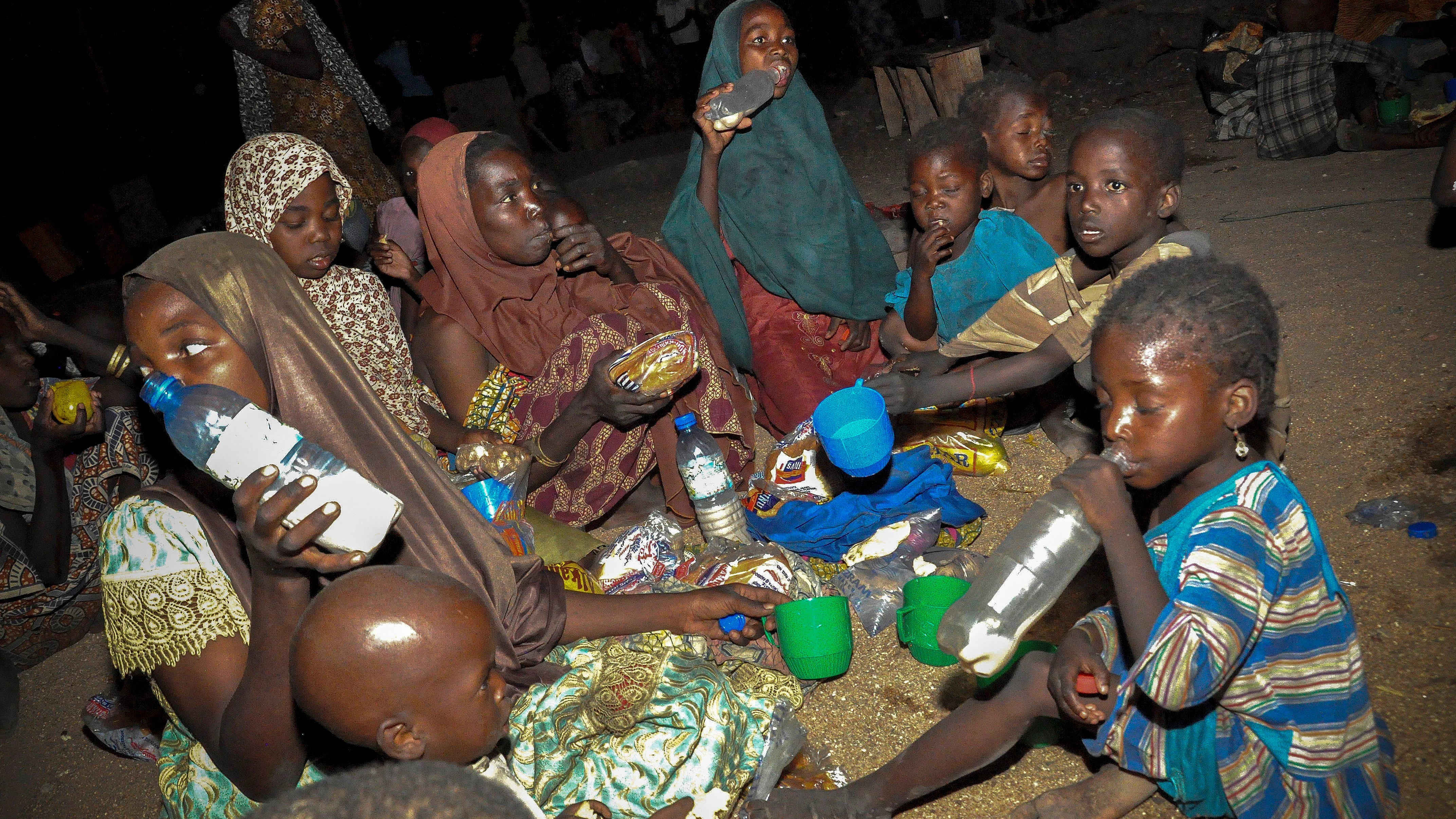 Una familia nigeriana come su ración de alimentos en un campamento de desplazados internos en Maiduguri (Nigeria)