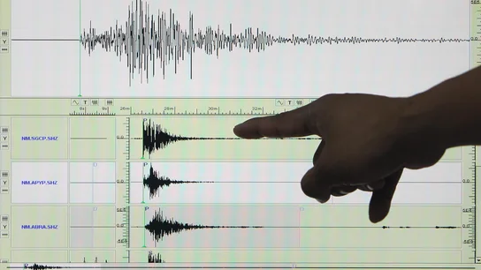Un experto señala en un sismógrafo el registro de un terremoto Un experto señala en un sismógrafo el registro de un terremoto