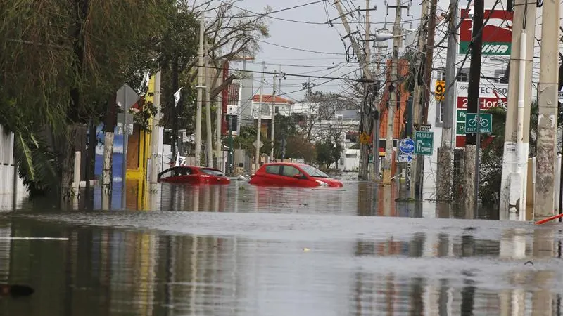  Dos coches flotan en una calle totalmente inundada en San Juan (Puerto Rico), tras el paso del huracán María.