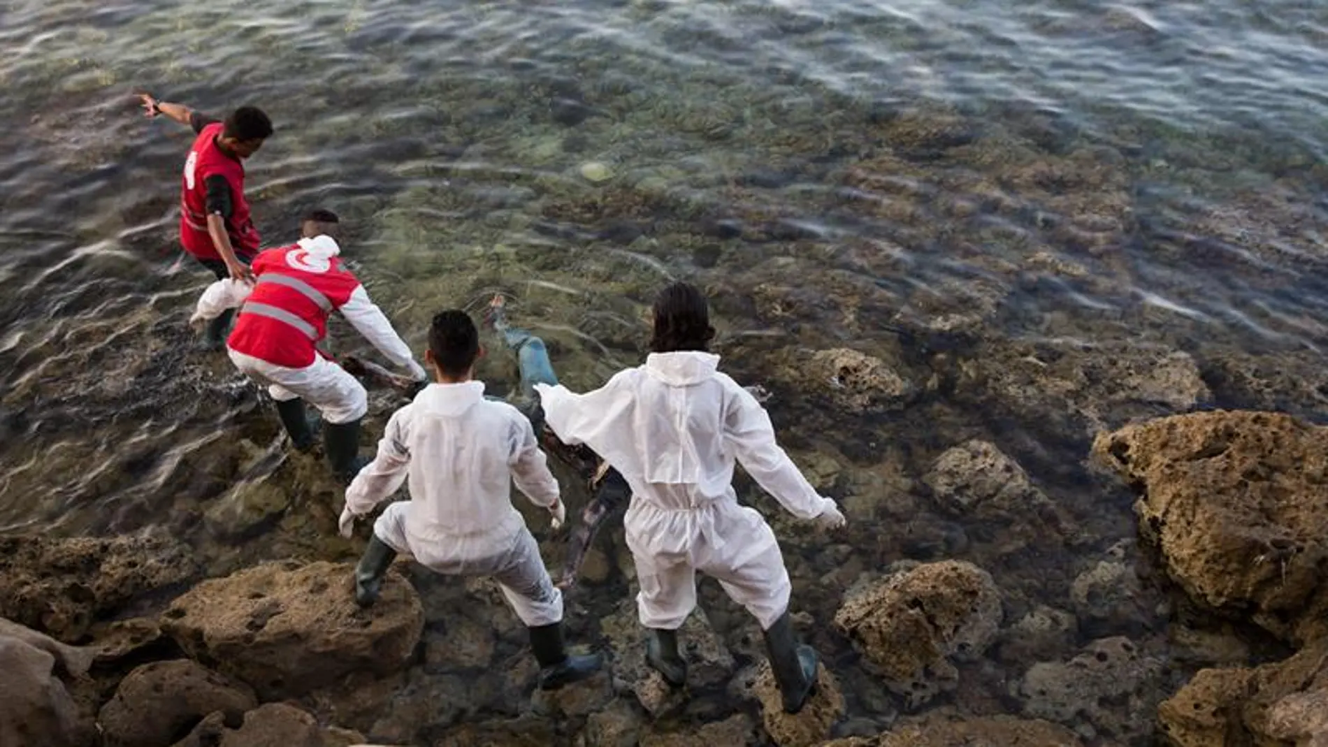Voluntarios recuperan cadáveres de inmigrantes en la costa de Tajoura, al este de Trípoli, en Libia, que se ahogaron el pasado mes de junio, tratando de llegar a Europa cruzando el Mediterráneo