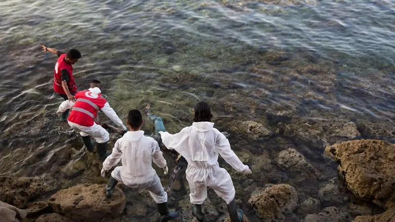 Voluntarios recuperan cadáveres de inmigrantes en la costa de Tajoura, al este de Trípoli, en Libia, que se ahogaron el pasado mes de junio, tratando de llegar a Europa cruzando el Mediterráneo