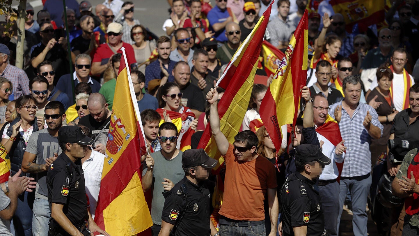 Un grupo de personas, con banderas espa&ntilde;olas, aplaude a los agentes de la Polic&iacute;a Nacional en la entrada al pabell&oacute;n Siglo XXI de Zaragoza