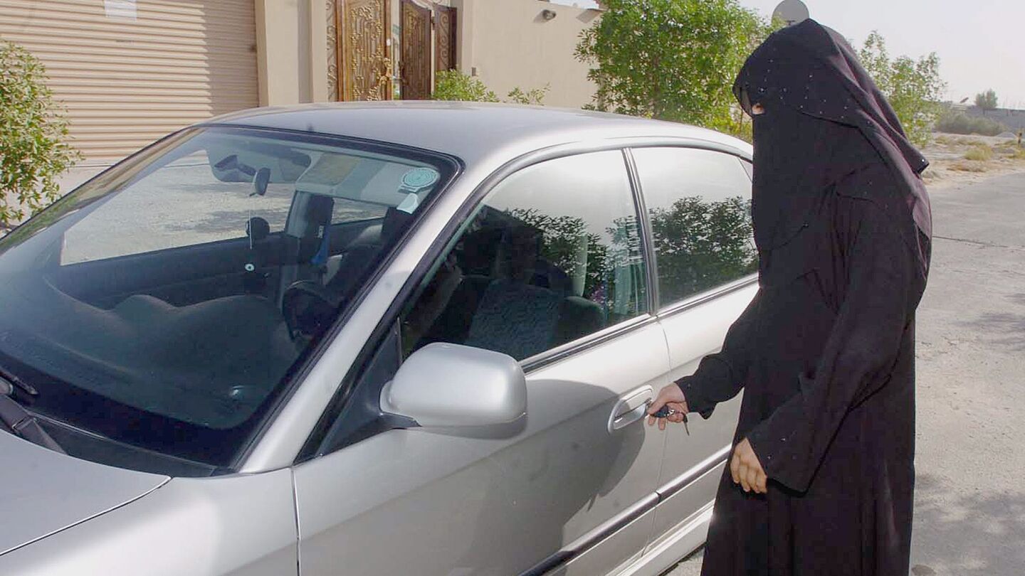 Una mujer saud&iacute; abre la puerta de un coche familiar en Riad, Arabia Saudi.