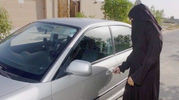 Una mujer saudí abre la puerta de un coche familiar en Riad, Arabia Saudi.