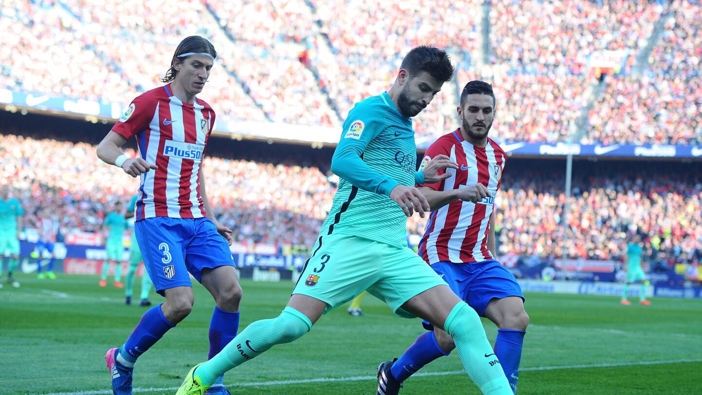 Piqu&eacute; intenta despejar el bal&oacute;n ante la presi&oacute;n de Filipe Luis y Koke