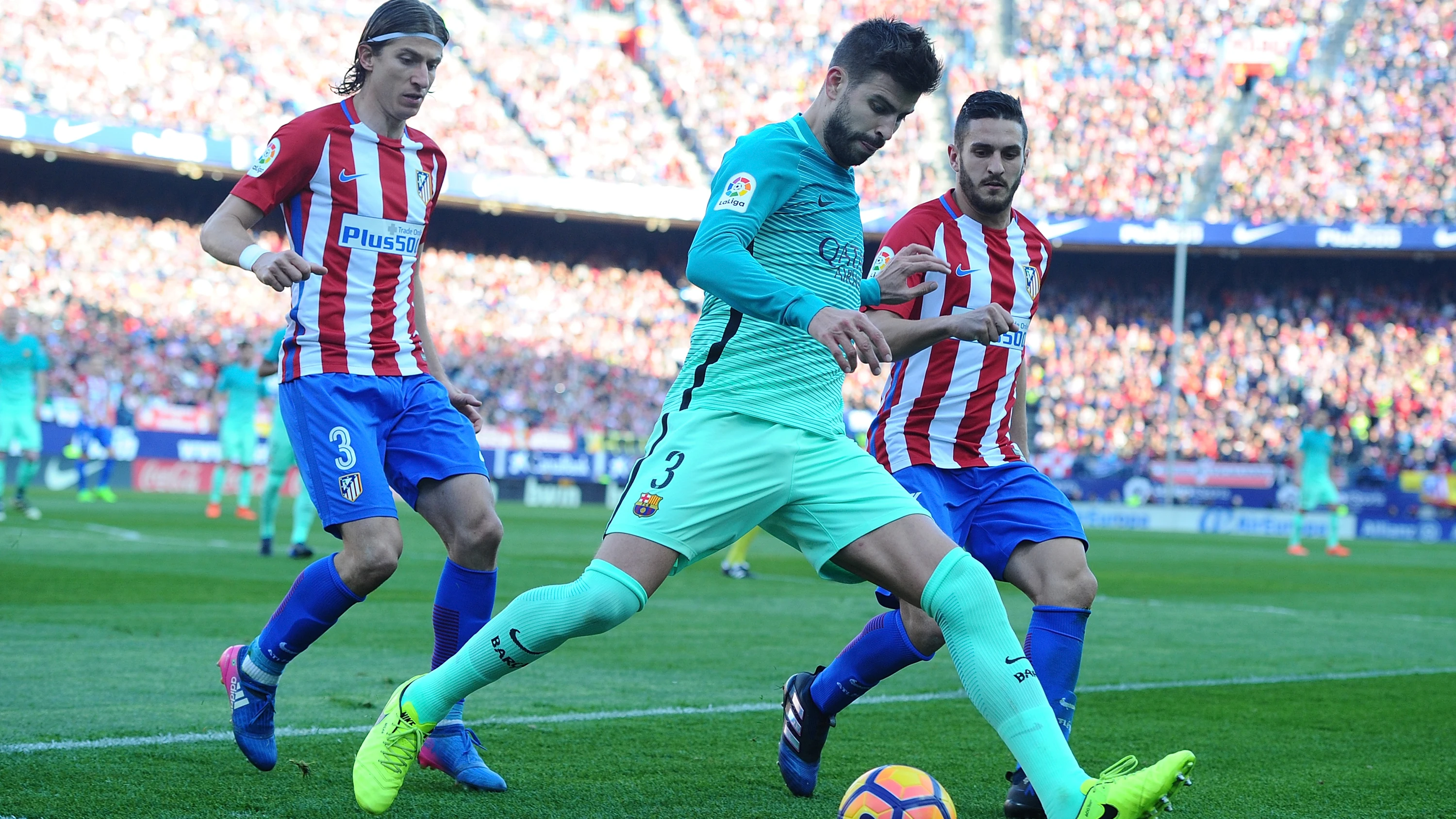 Piqu&eacute; intenta despejar el bal&oacute;n ante la presi&oacute;n de Filipe Luis y Koke