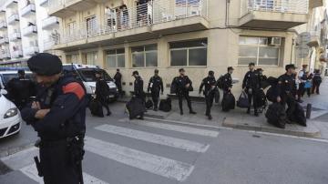 Un grupo de policías nacionales espera su transporte delante del hotel Mont-Palau de Pineda