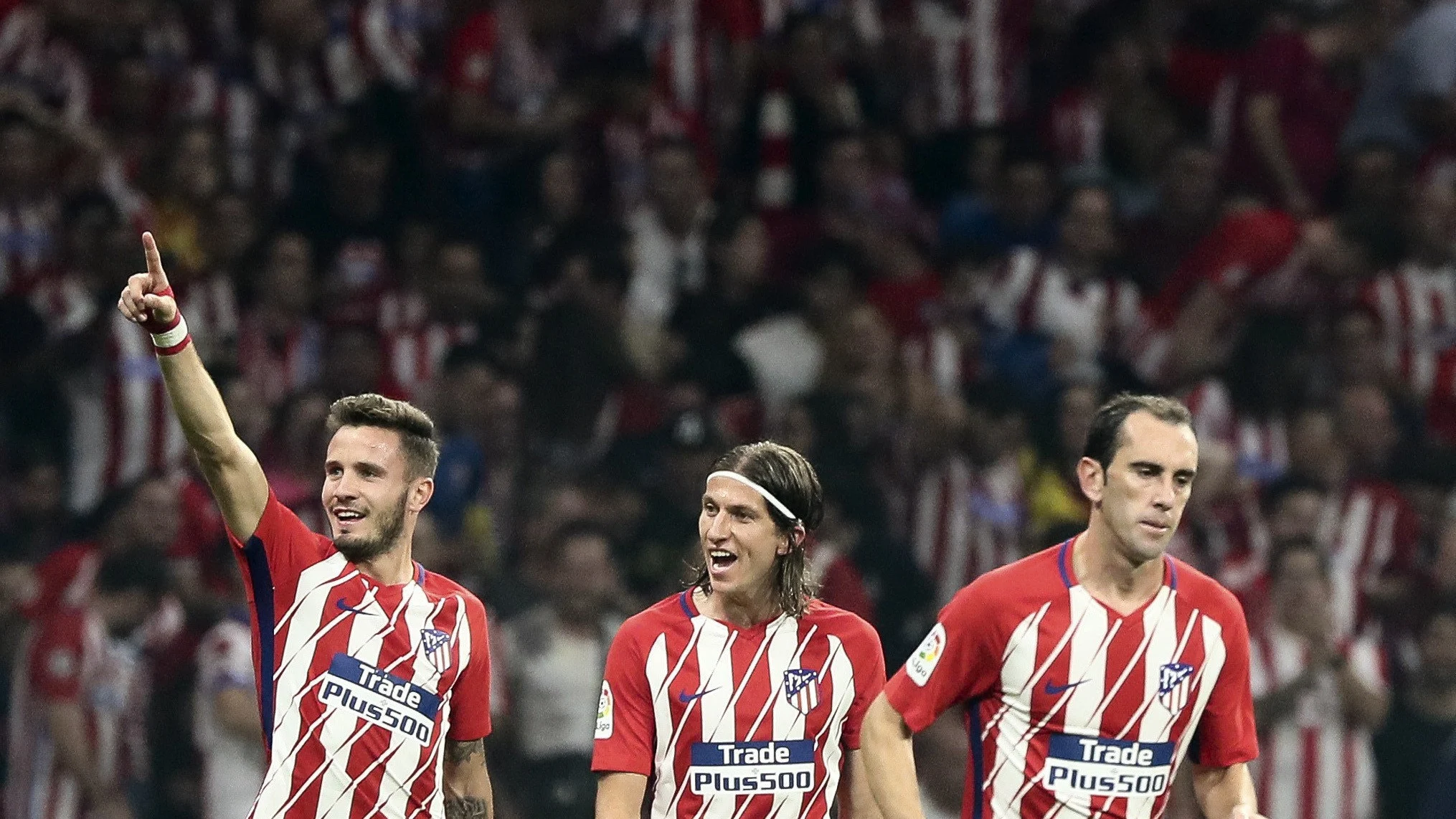Saúl celebra con Filipe Luis y Godín un gol del Atlético