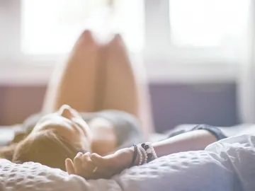 Una mujer tumbada sobre una cama Una mujer tumbada sobre una cama