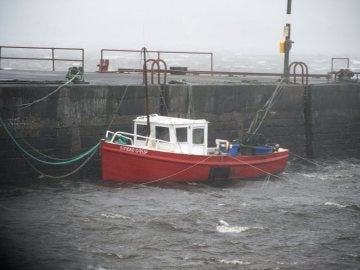 Vista de un barco amarrado a un muelle en el condado de Clare, en la costa atlántica irlandesa Vista de un barco amarrado a un muelle en el condado de Clare, en la costa atlántica irlandesa