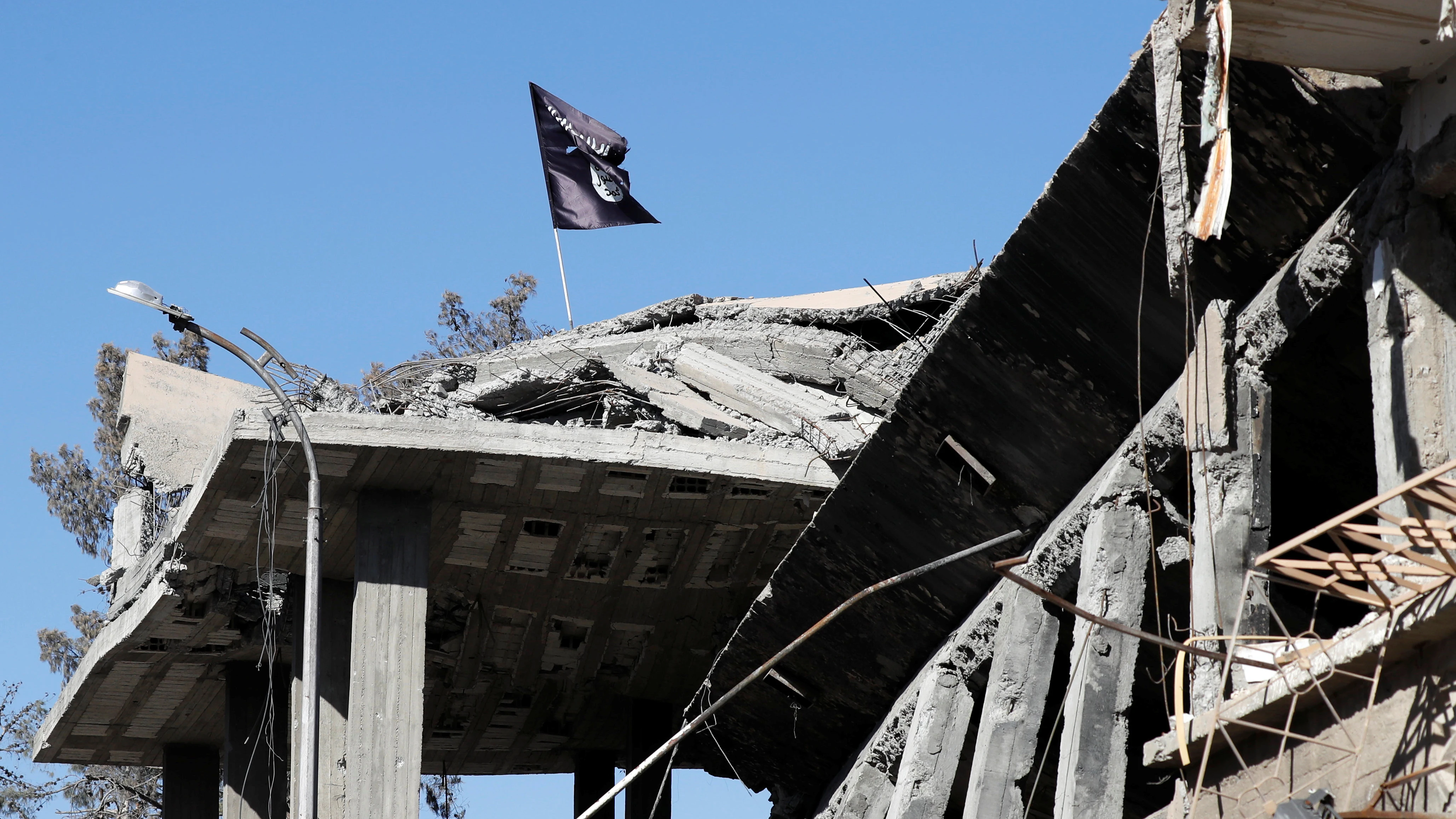 Una bandera de Daesh ondea sobre un edificio destruido cerca de la Plaza del Reloj de siria