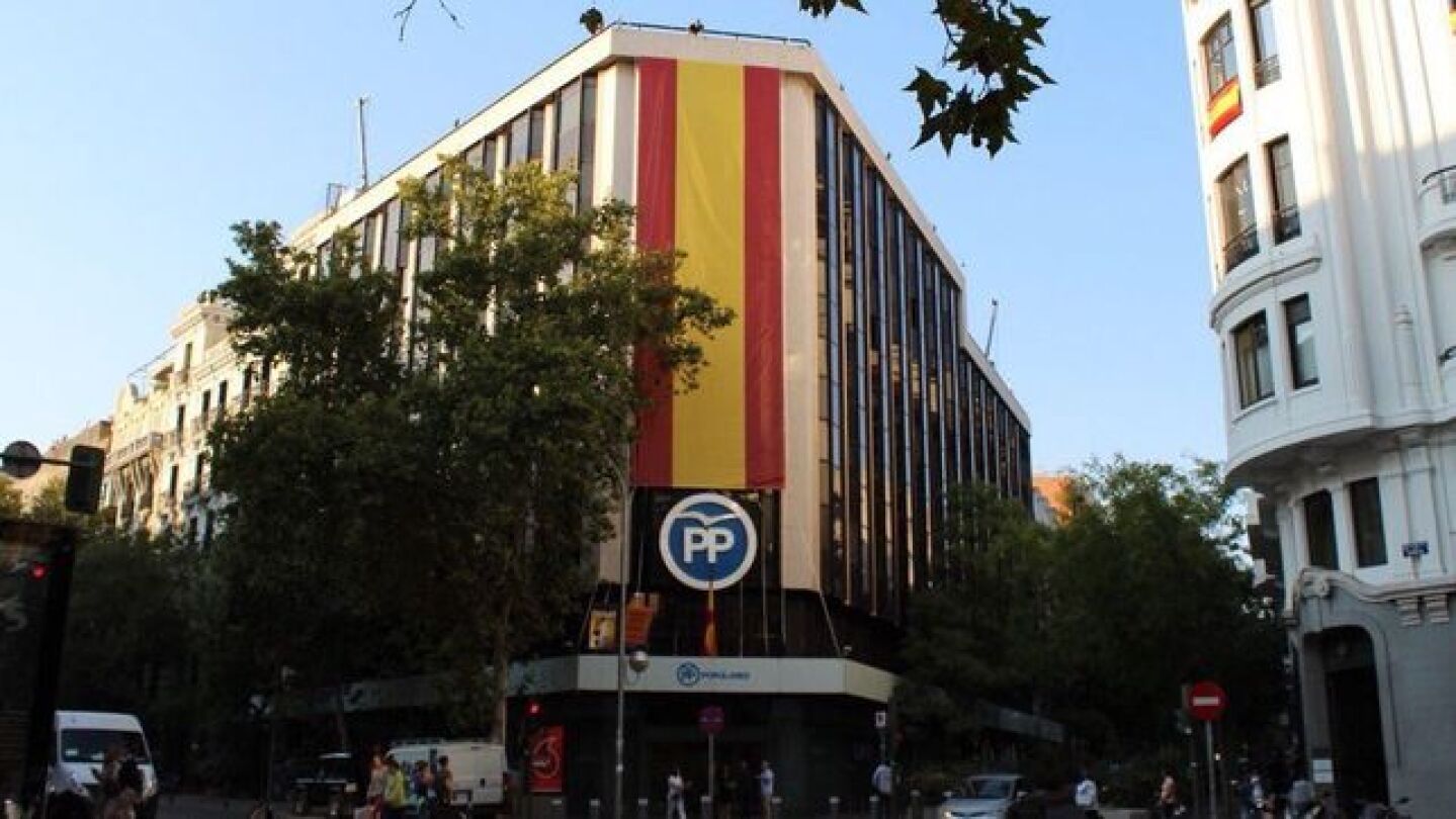 El PP despliega una bandera de Espa&ntilde;a en la fachada de G&eacute;nova