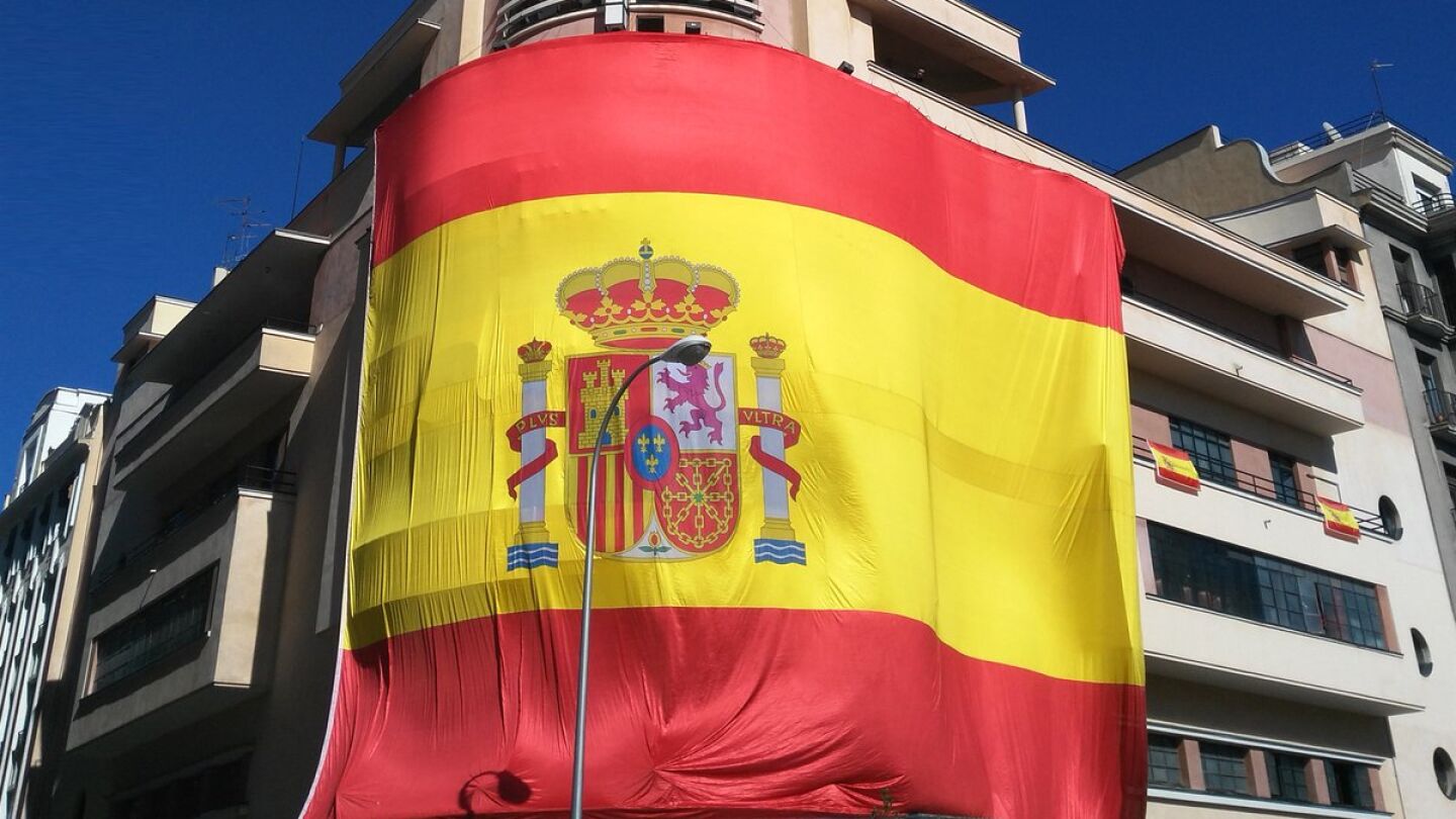 Gran bandera de Espa&ntilde;a colgada en la fachada del Teatro Barcel&oacute;