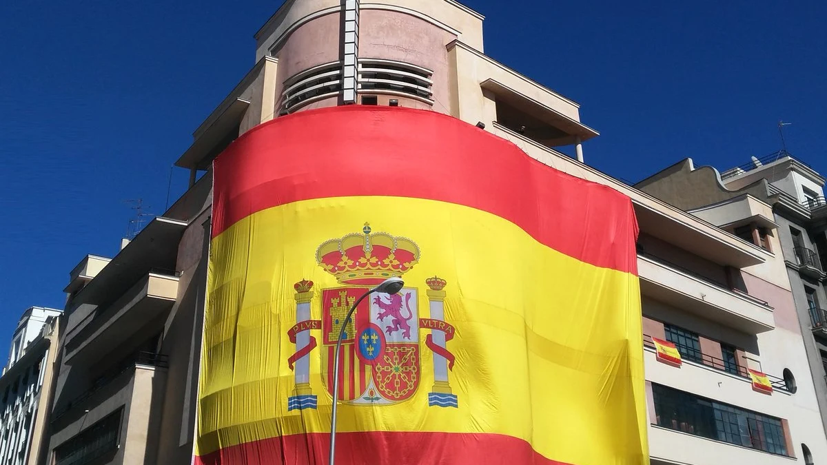 Gran bandera de Espa&ntilde;a colgada en la fachada del Teatro Barcel&oacute;