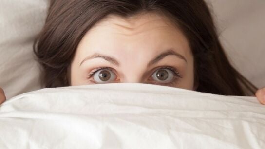 Ojos de mujer acostada en la cama