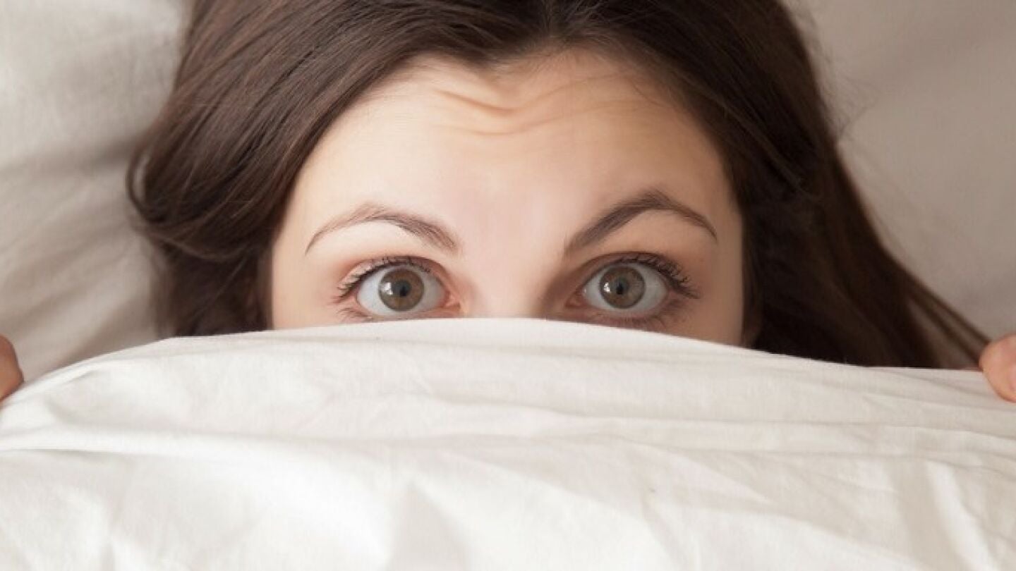 Ojos de mujer acostada en la cama