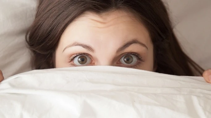 Ojos de mujer acostada en la cama