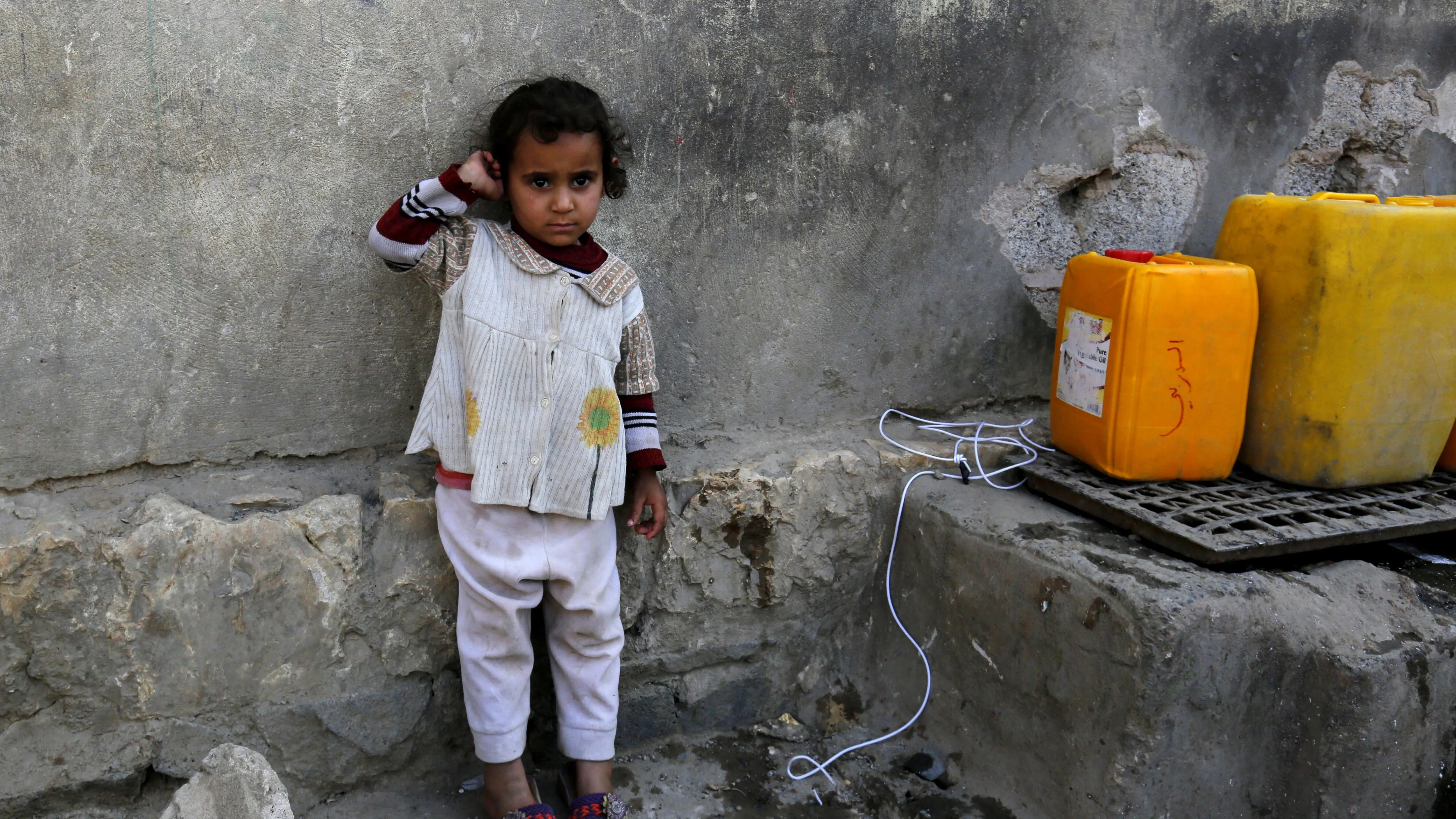  Una niña yemení espera para llenar sus garrafas de agua potable en Saná