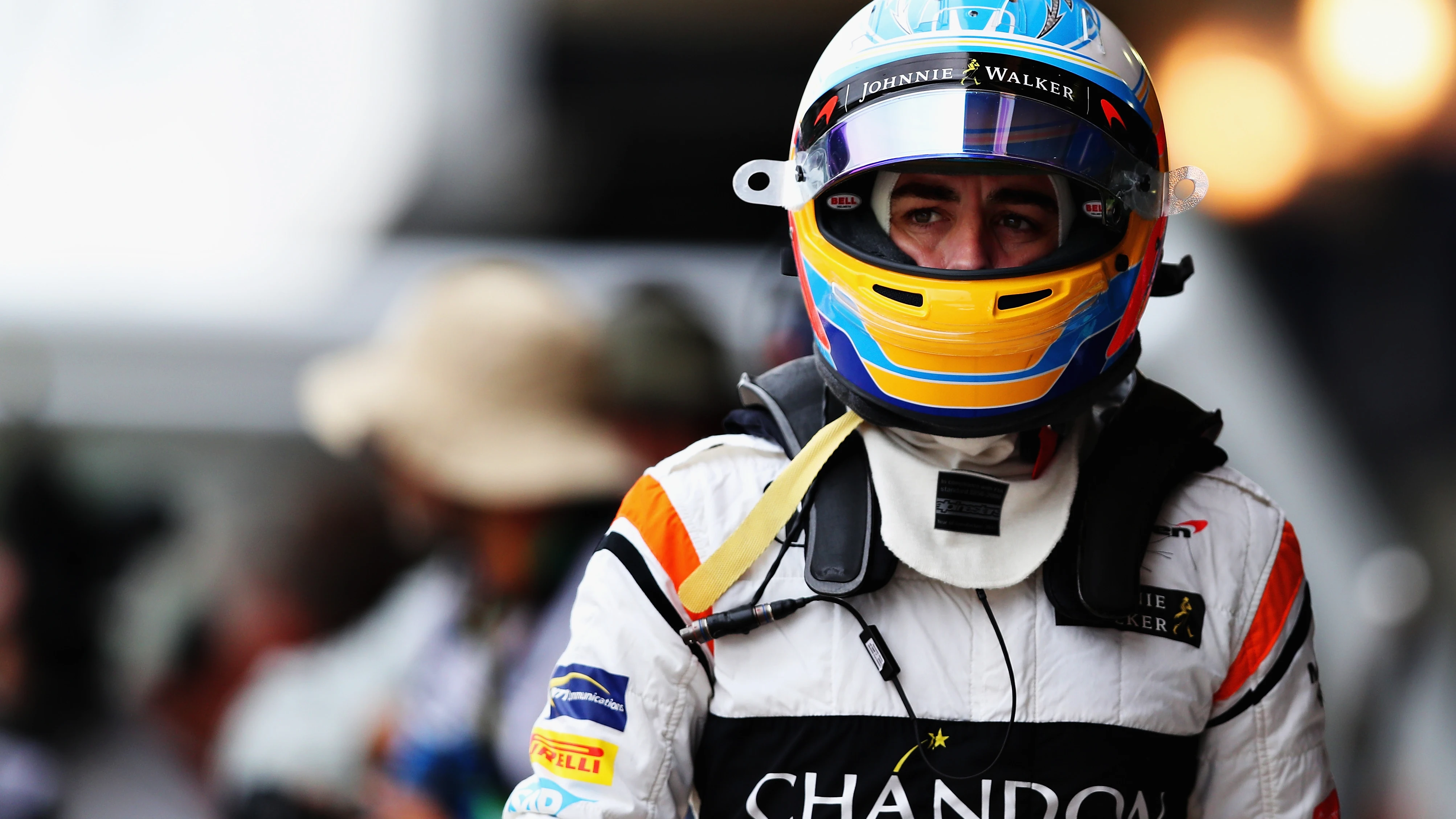 Fernando Alonso pasea por el paddock con el casco