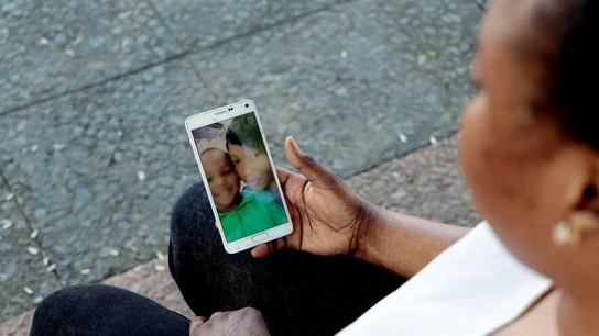 Ouma muestra una foto de su hijo con ella Ouma muestra una foto de su hijo con ella