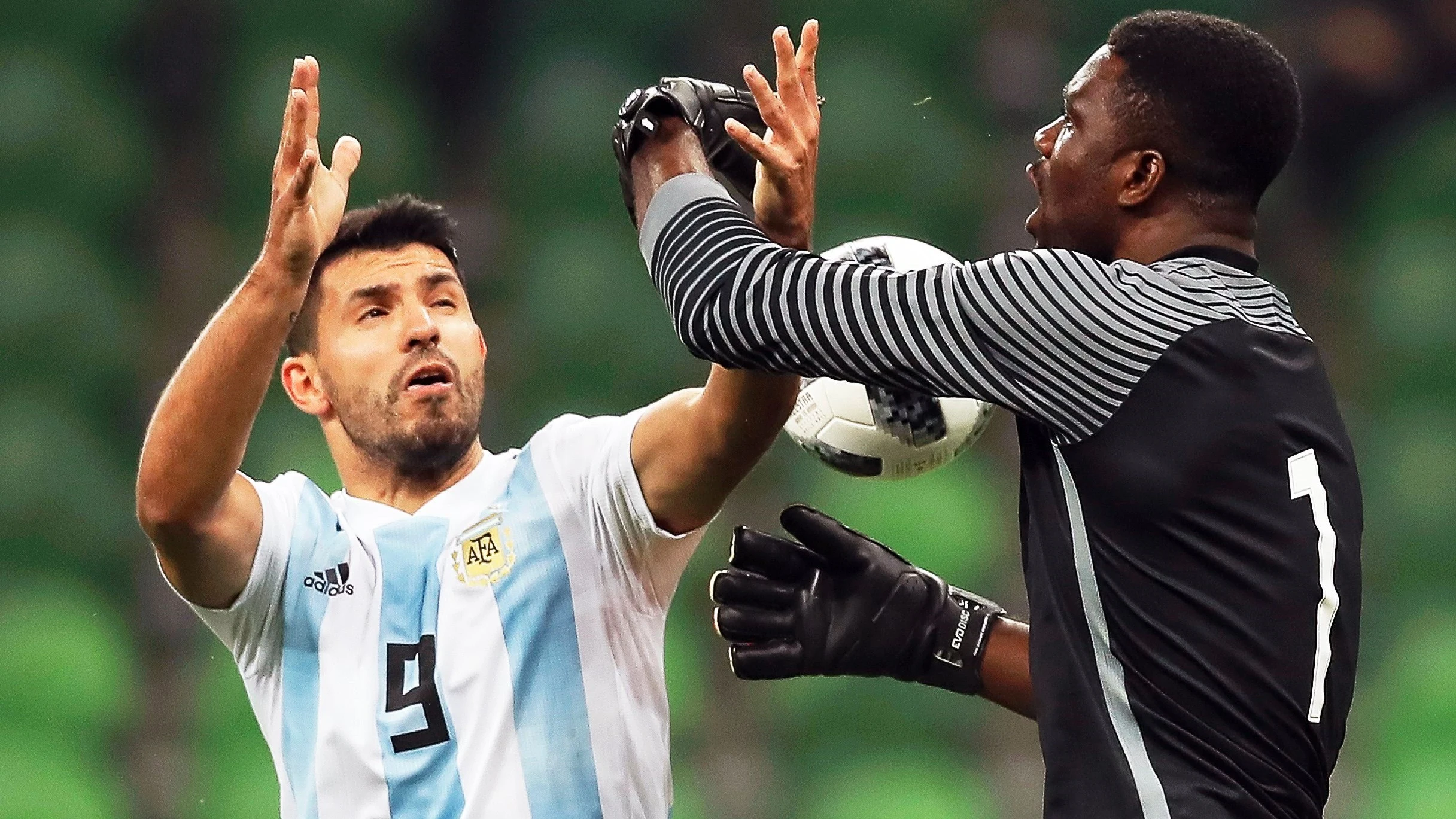 Akpeyi intenta atrapar un balón ante la presión de Agüero