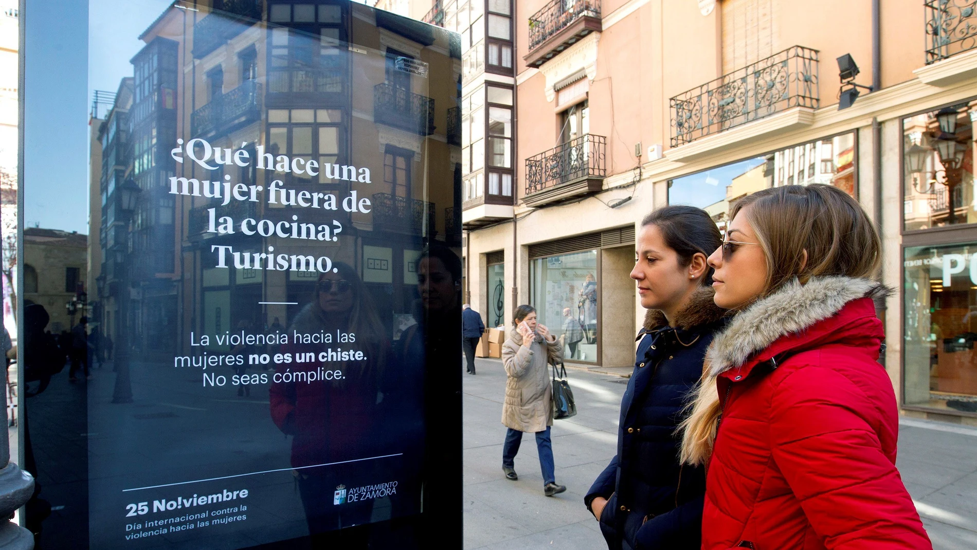 Dos mujeres observan uno de los carteles ubicados por las calles zamoranas de la campaña iniciada por el Ayuntamiento de Zamora