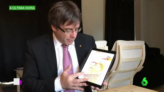 Puigdemont junto a su cartel electoral Puigdemont junto a su cartel electoral