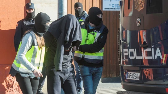 Agentes de la Policía Nacional acompañan a uno de los detenidos en Figueras, Gerona Agentes de la Policía Nacional acompañan a uno de los detenidos en Figueras, Gerona