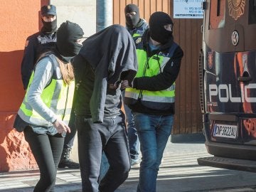 Agentes de la Policía Nacional acompañan a uno de los detenidos en Figueras, Gerona Agentes de la Policía Nacional acompañan a uno de los detenidos en Figueras, Gerona