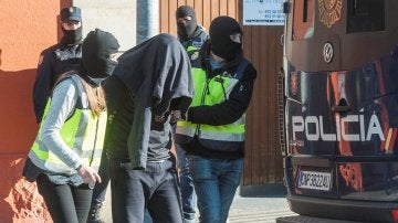 Agentes de la Policía Nacional acompañan a uno de los detenidos en Figueras, Gerona