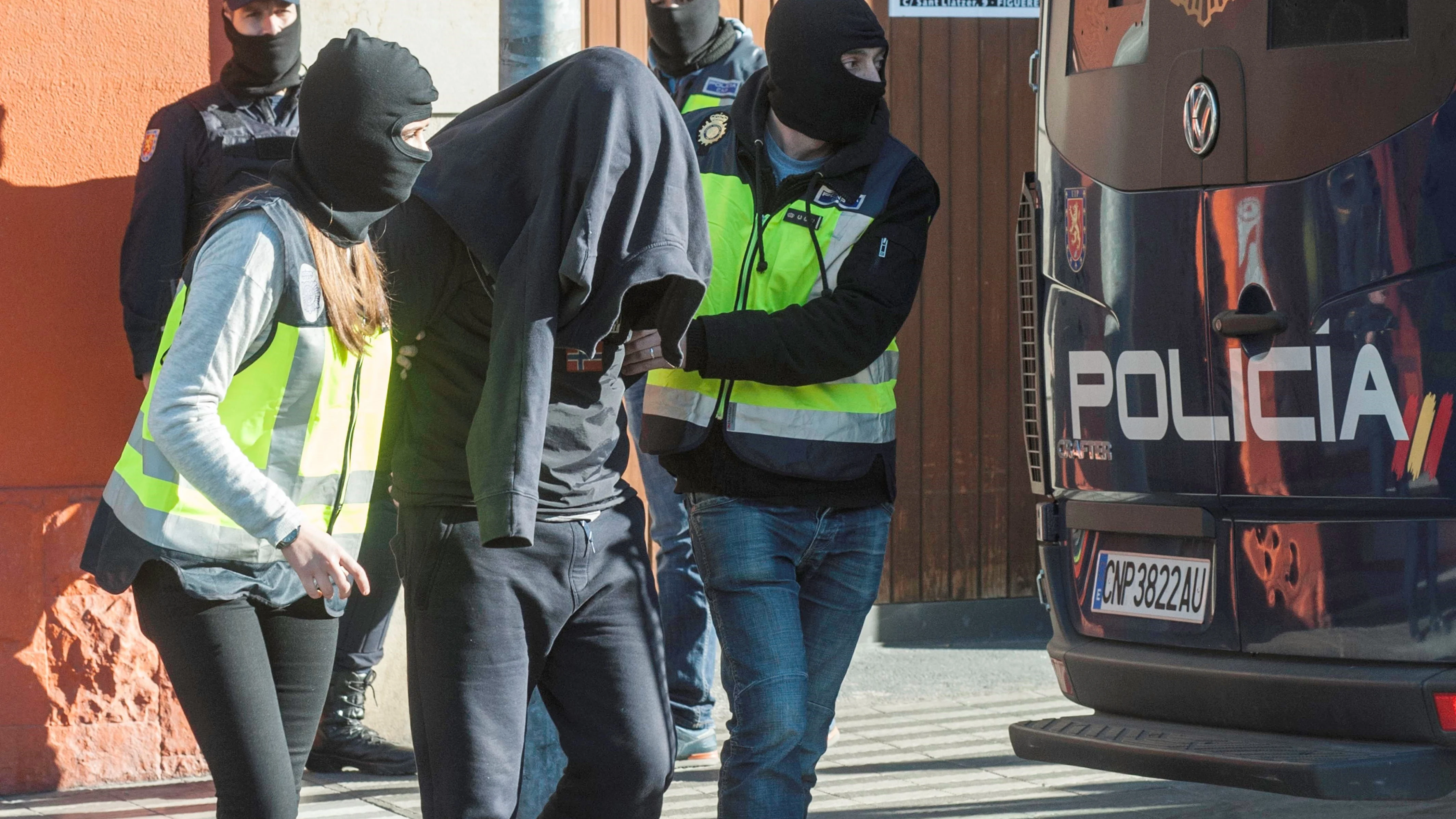 Agentes de la Policía Nacional acompañan a uno de los detenidos en Figueras, Gerona