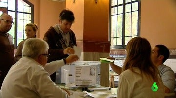 Unos ciudadanos depositan sus votos en una urna