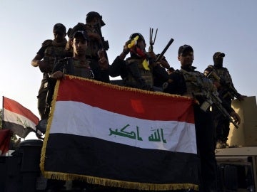 Imagen de archivo de soldados iraquíes sosteniendo la bandera nacional en el centro de Mosul Imagen de archivo de soldados iraquíes sosteniendo la bandera nacional en el centro de Mosul