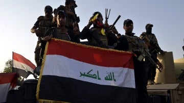 Imagen de archivo de soldados iraquíes sosteniendo la bandera nacional en el centro de Mosul