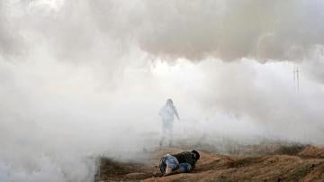Manifestantes palestinos se cubren durante los enfrentamientos cerca de la frontera con Israel