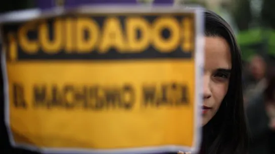 Una joven llevando un cartel contra el machismo Una joven llevando un cartel contra el machismo