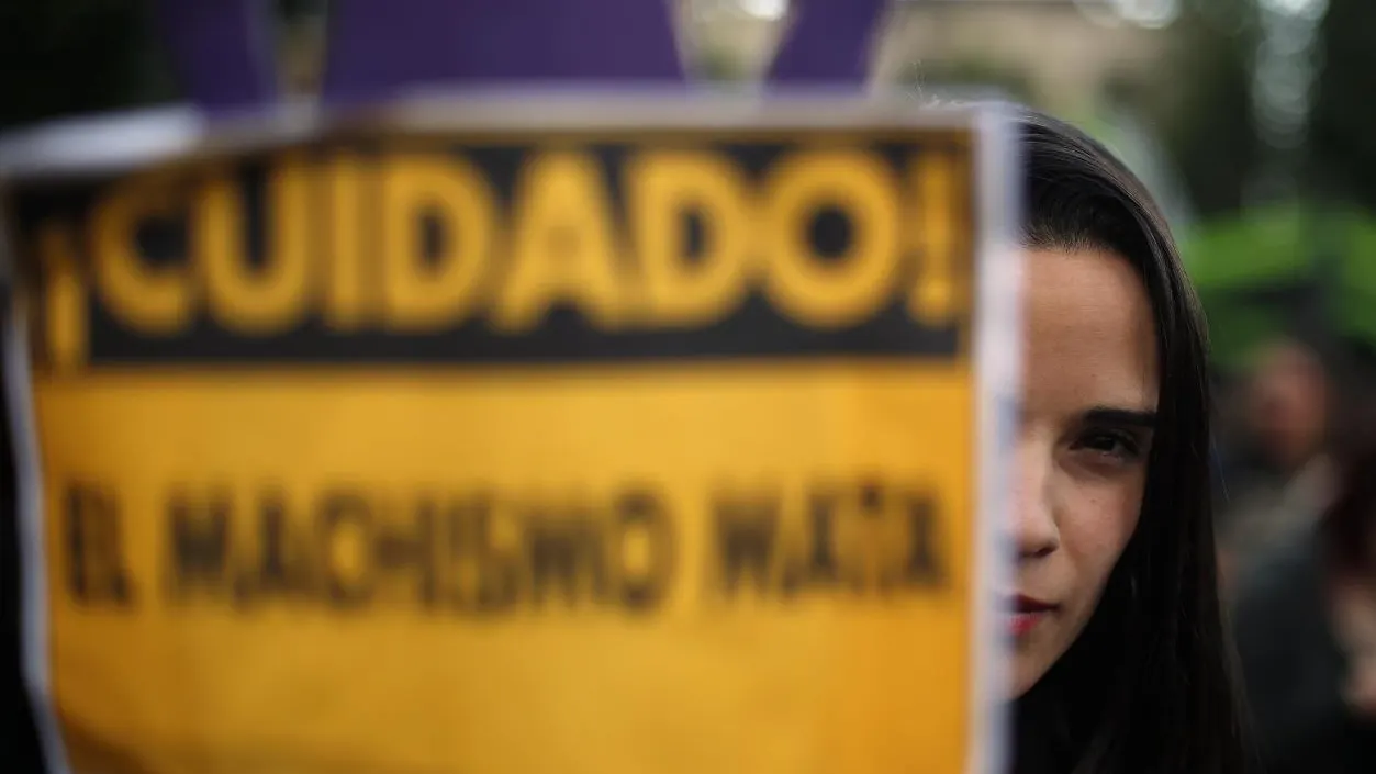 Una joven llevando un cartel contra el machismo