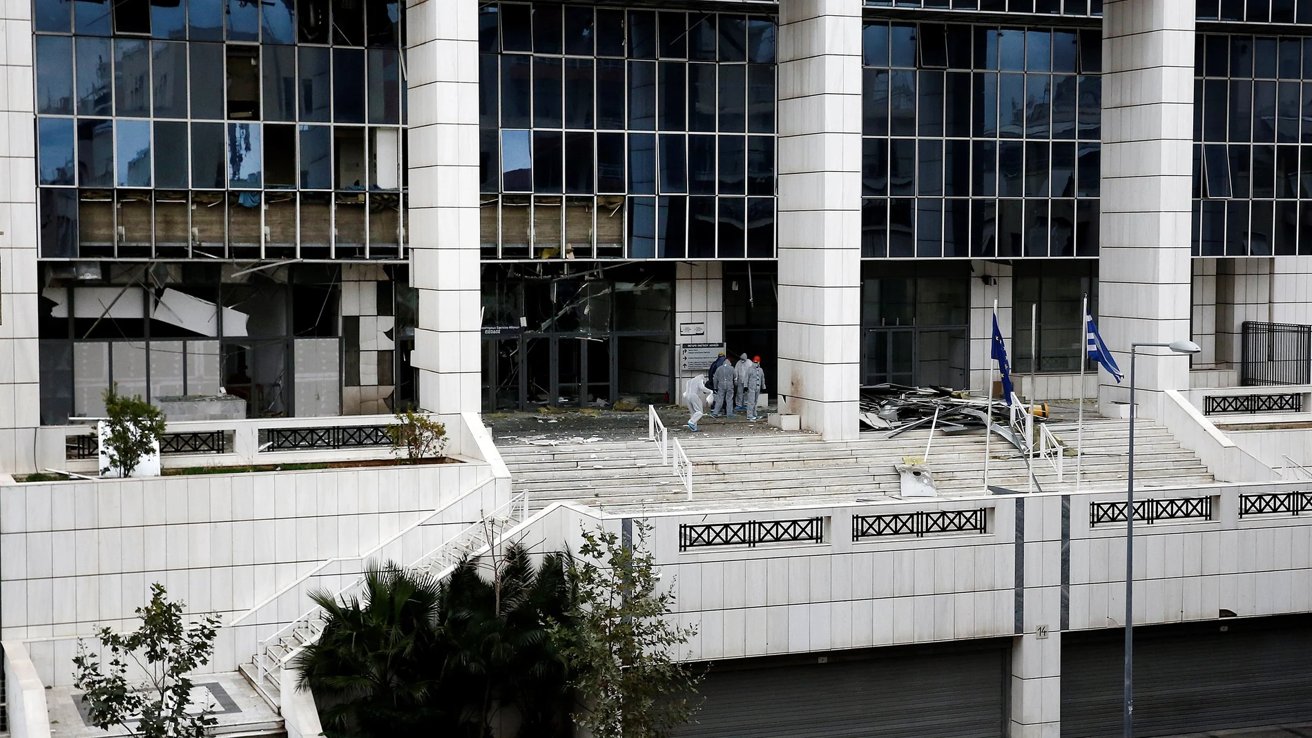 Policías recaban pruebas después de que un artefacto explosivo estallase esta madrugada ante el Tribunal de Apelaciones de Atenas