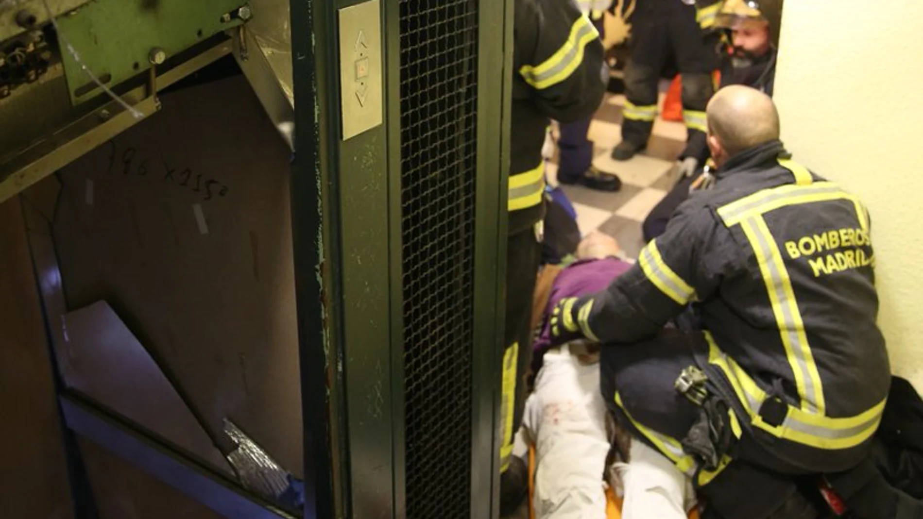 Los bomberos atienden a una de las heridas tras descolgarse el ascensor