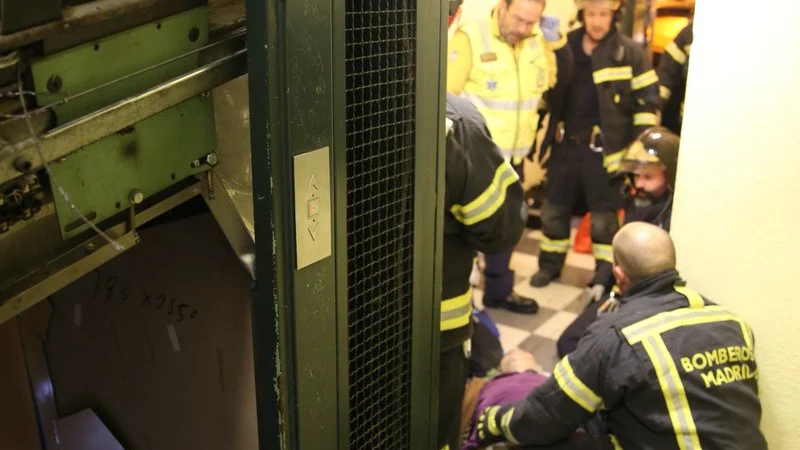 Los bomberos atienden a una de las heridas tras descolgarse el ascensor