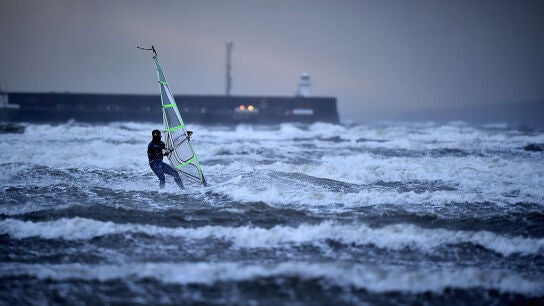Un hombre practica windsurf en el mar