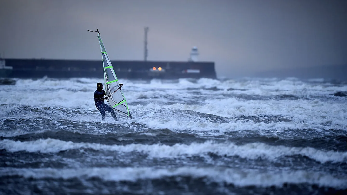 Un hombre practica windsurf en el mar Un hombre practica windsurf en el mar