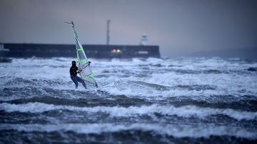 Un hombre practica windsurf en el mar