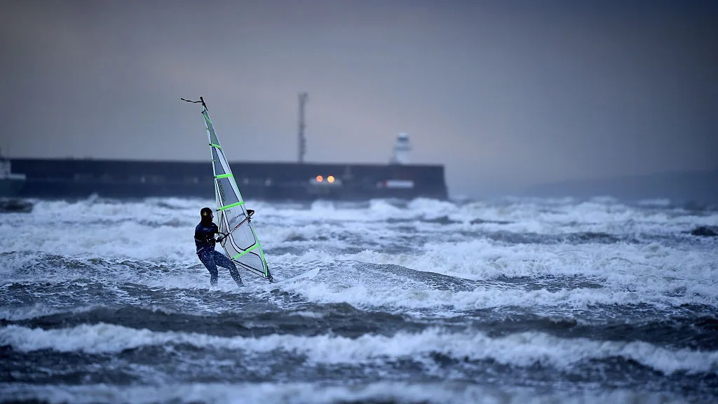Un hombre practica windsurf en el mar Un hombre practica windsurf en el mar