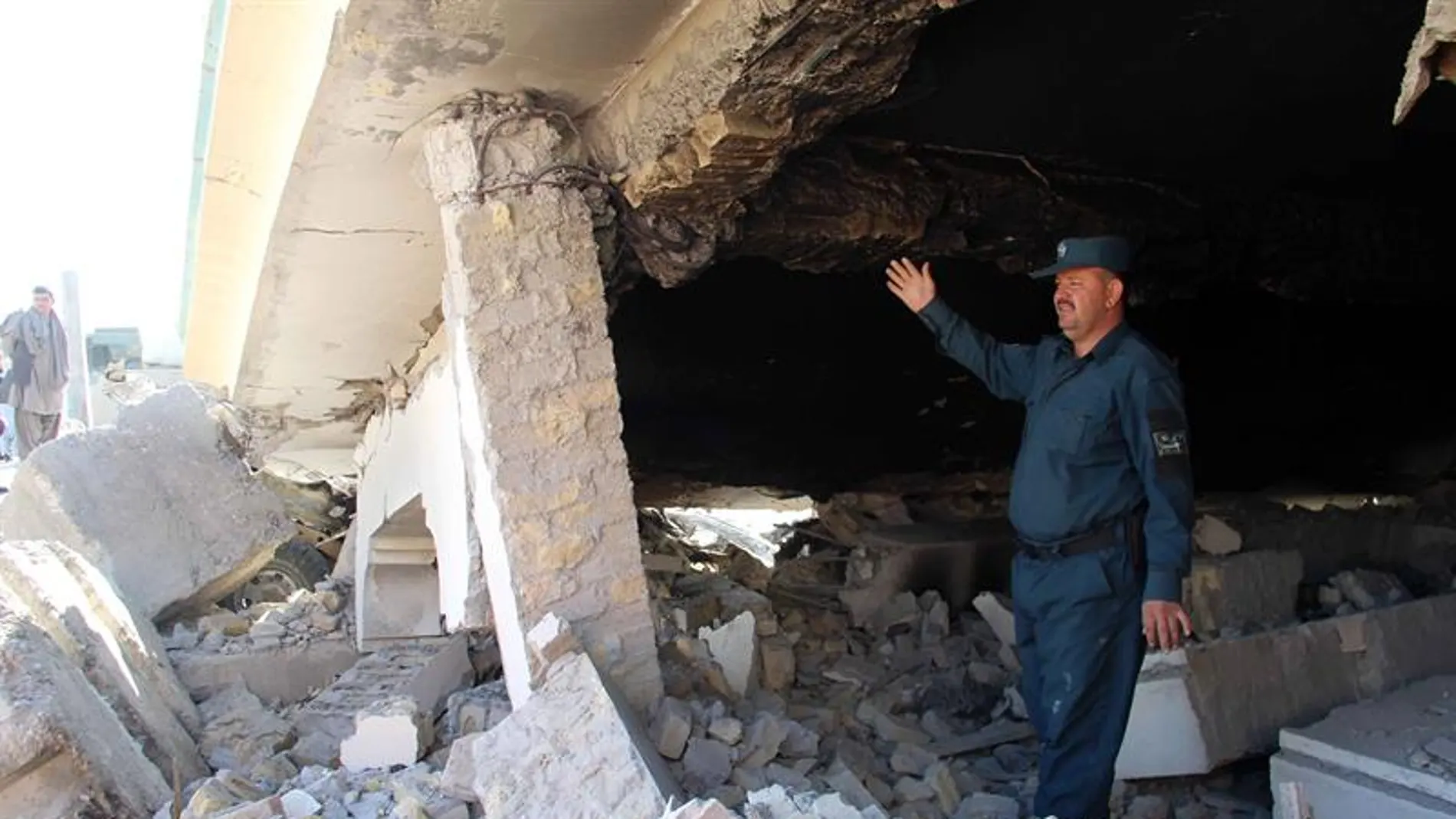 Un oficial de seguridad inspecciona los daños en el escenario de un atentado suicida en Afganistán