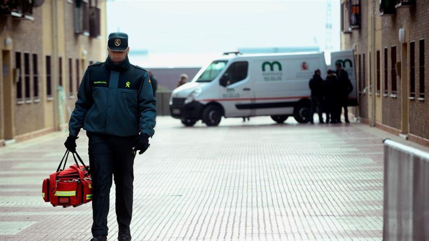 Un coche de los servicios funerarios espera en el domicilio de Azuqueca de Henares 