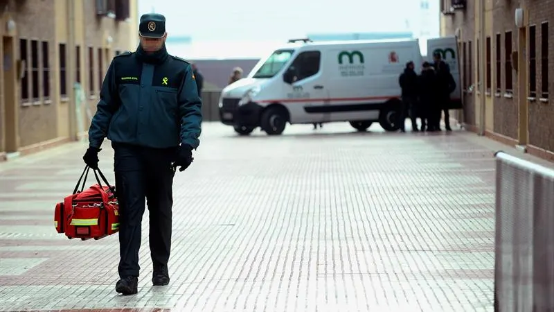 Un coche de los servicios funerarios espera en el domicilio de Azuqueca de Henares 