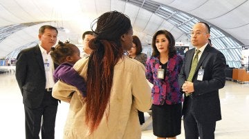 Personal del aeropuerto hablan con miembros de la familia zimbabuense que ha permanecido tres meses en el Aeropuerto Internacional Suvarnabhumi en la provincia de Samut Prakan, a las afueras de Bangkok,