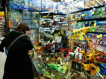 Una mujer contempla los artículos expuestos en el escaparate de una juguetería