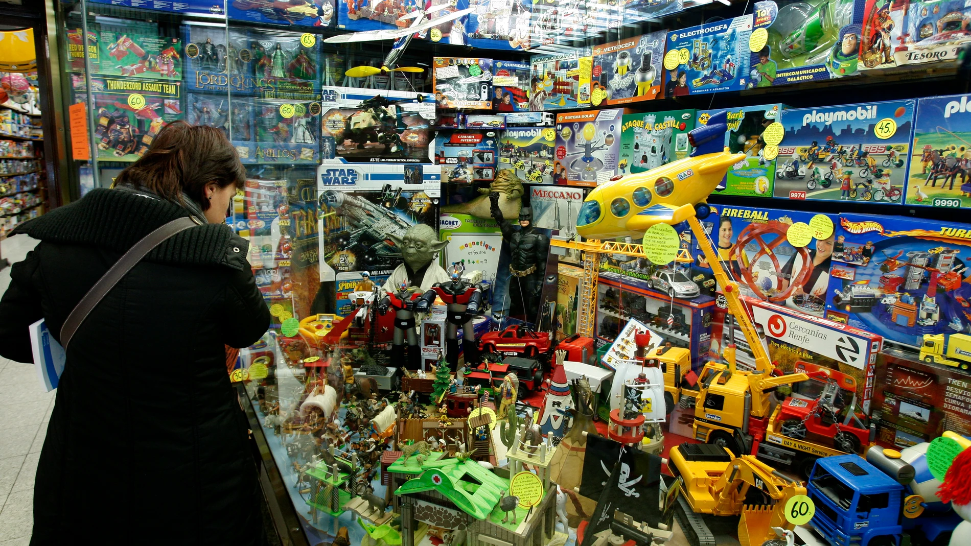 Una mujer contempla los artículos expuestos en el escaparate de una juguetería
